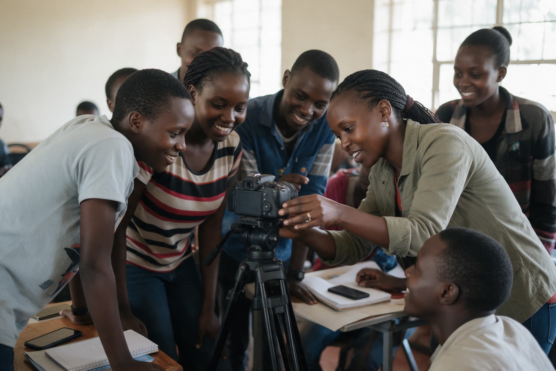 A trainer showing a group of young people how to set up a camera