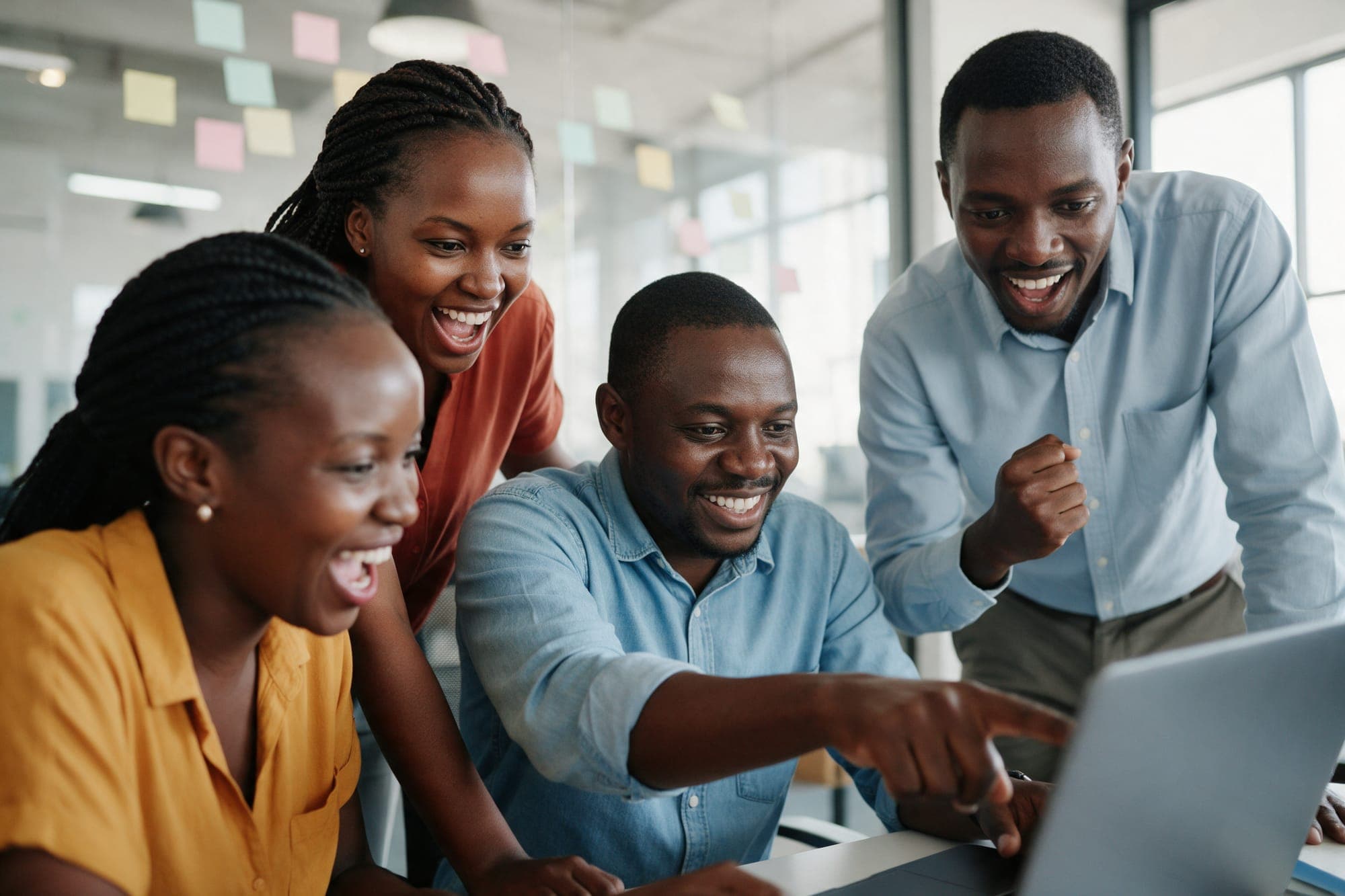 A communications team gathered round a laptop in a workshop